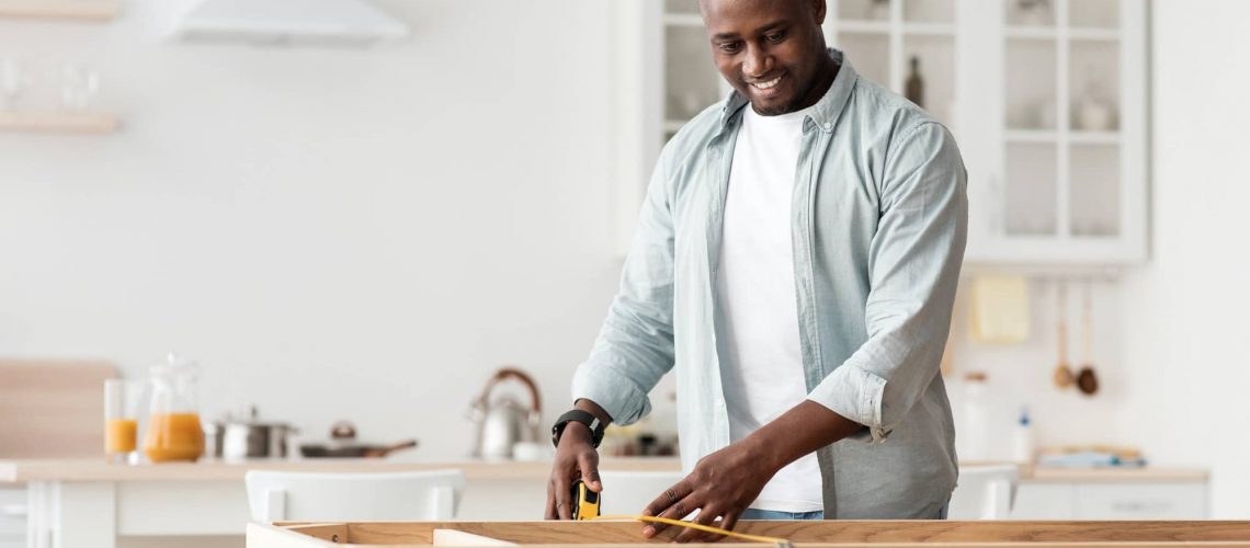 Handyman working at home, repairing, assembling and renovation or new hobby. Man measuring new table