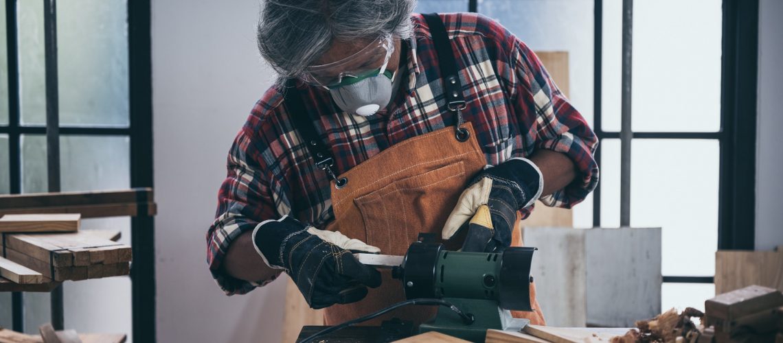 old carpenter man working in carpenter studio